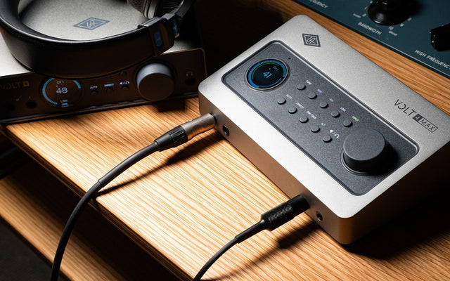 Universal Audio Volt MAX 4 and Volt 4 Gen 2 audio interfaces sitting on a desk.