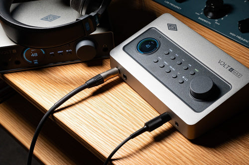 Universal Audio Volt MAX 4 and Volt 4 Gen 2 audio interfaces sitting on a desk.